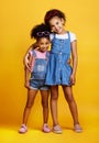 Children, hug and happy portrait of sisters in studio with love, care and support on yellow background. Cute young girl Royalty Free Stock Photo