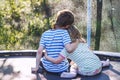 Children hugging in the garden on trampoline.