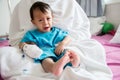 Children illness . Little Baby attaching intravenous tube to patient`s hand in hospital bed. Baby sick and crying on mom .