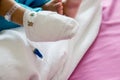 Children illness . Little Baby attaching intravenous tube to patient`s hand in hospital bed.