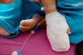 Children illness . Little Baby attaching intravenous tube to patient`s hand in hospital bed.