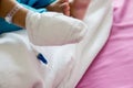 Children illness . Little Baby attaching intravenous tube to patient`s hand in hospital bed.