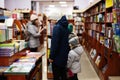 Children in jacket reaching a book from bookshelf at the library. Learning and education of european kids Royalty Free Stock Photo