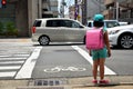 Children japanese girl waiting cross over road at crosswalk traffic road after finished study class at school near Gojo subway st