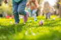 Children on a Joyful Easter Egg Hunt in Sunlit Garden. Kids legs in a park, with colorful eggs dotting the grass on a sunny day. Royalty Free Stock Photo