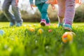 Children on a Joyful Easter Egg Hunt in Sunlit Garden. Kids legs in a park, with colorful eggs dotting the grass on a sunny day. Royalty Free Stock Photo