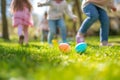 Children on a Joyful Easter Egg Hunt in Sunlit Garden. Kids legs in a park, with colorful eggs dotting the grass on a sunny day. Royalty Free Stock Photo
