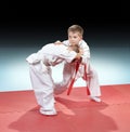 Children in judogi are training capture on gradient background