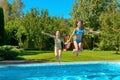 Children jump to swimming pool water and have fun, kids on family vacation Royalty Free Stock Photo
