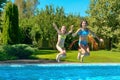 Children jump to swimming pool water and have fun, kids on family vacation Royalty Free Stock Photo