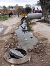 Children jumping over a ditch by sewage