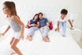 Children Jumping On Parents Bed Wearing Pajamas Royalty Free Stock Photo