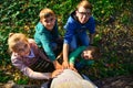 Children keep their hands on the belly of a pregnant mom in the forest on the nature on a background of green grass