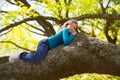 Children kid girl resting lying on a tree branch Royalty Free Stock Photo