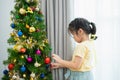 Children kids girl decorating christmas tree for celebrate christmas and new year party at home. Preparing for holiday. Happiness Royalty Free Stock Photo