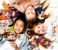 Children kids playing in kindergarten girls lying on a floor with little doll toys happy screaming laughing