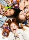 Children kids playing in kindergarten girls lying on a floor with little doll toys happy screaming laughing