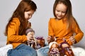 Children kids playing in kindergarten girls sitting on a floor with little doll toys happy laughing on a gray wall