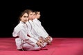 Children in kimono sitting on tatami on martial arts seminar. Selective focus Royalty Free Stock Photo