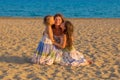 Children kissing and hugging mother at the beach.