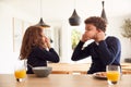 Children At Kitchen Counter Eating Breakfast And Pulling Faces Before Going To School Royalty Free Stock Photo