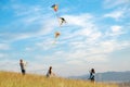 Children kite fighting with flying colorful kites - popular outdoor toy on the high grass mountain meadow. Happy childhood moments Royalty Free Stock Photo