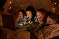 Children, laptop and watch in tent at night with movies, film or cartoons for holiday adventure or vacation. Young boy Royalty Free Stock Photo