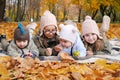 Children from a large family, four happy children lie on a plaid blanket in an autumn park Royalty Free Stock Photo