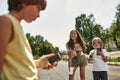 Children laugh from confused boy with old phone Royalty Free Stock Photo