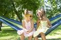 Children laughter. Beautiful and cheerful little girls laughing, while sitting on a hammock