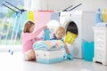Kids in laundry room with washing machine Royalty Free Stock Photo