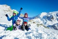 Children lay in snow and wave hands over mountains Royalty Free Stock Photo