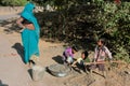 Children learn by mother how to repair roads