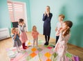 Children learning body parts with teacher in kindergarden. Royalty Free Stock Photo