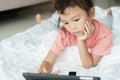 Children are learning by themselves through online media. Asian girl are using tablet to watch video via the internet for home Royalty Free Stock Photo