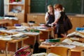 The children left their satchels and notebooks on the tables and went to recess. Three small students stayed in class to discuss Royalty Free Stock Photo