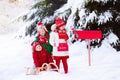 Children with letter to Santa at Christmas mail box in snow Royalty Free Stock Photo