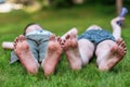 Children lie on the grass, feet on foreground