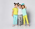 Children on a light background: shot of three children in bright clothes, two girls and one boy. Triplets, brother and sisters.