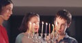 Children lighting Hanukka candles at home