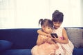 Children listening to music while sitting on a couch Royalty Free Stock Photo