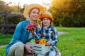 Children little girl holding mom a basket of fresh organic vegetables with the home garden. Royalty Free Stock Photo