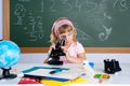 Children little girl at school with microscope