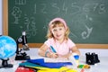 Children little girl at school with microscope