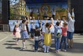 Children little girls boys playing game hands up, musicians playing music on a background. Ethno Fest. Kyiv, Ukraine