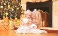 Children little girls with gift boxes near christmas tree and fireplace home Royalty Free Stock Photo