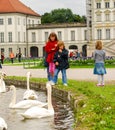 Children look at swans in a pond
