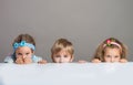 Children looking at camera from behind the table Royalty Free Stock Photo