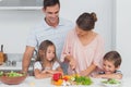 Children looking at their mother who is preparing vegetables Royalty Free Stock Photo