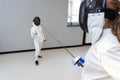 Children lunge on swords. A child in a class at a fencing school